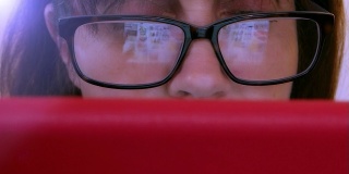 女性使用数码平板电脑，眼镜反光。