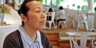 在咖啡厅微笑的日本老妇人