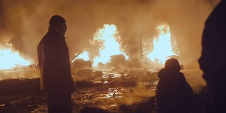 抗议者站在燃烧的货车前