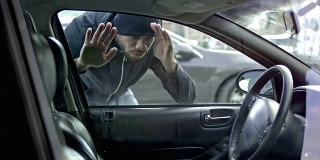 小偷从外面检查汽车准备偷车