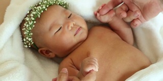 婴儿抱着妈妈的手指