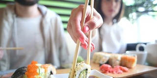 一对幸福的夫妇在日本餐厅吃寿司卷