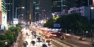 广州城市街道上繁忙的交通和现代化的建筑在晚上，时间流逝。
