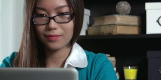 在家庭办公室里看笔记本电脑的亚洲女性