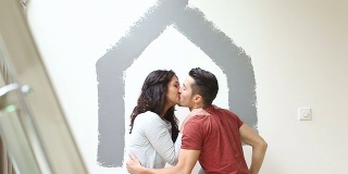 情侣刷墙与油漆辊和亲吻