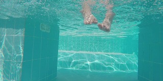 小男孩在游泳池里溅脚