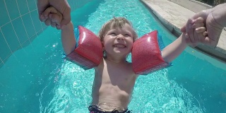 小男孩在游泳池里旋转