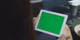 近距离观察手持绿色平板电脑的女性