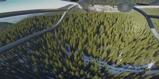 冬季，POV直升机飞过树木覆盖的山峰