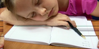 昏昏欲睡的女学生在写抄写本