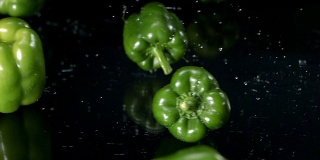 高清超级慢镜头:湿青椒落在黑玻璃上
