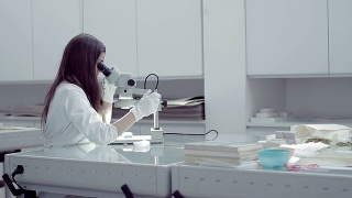 女性研究员使用显微镜视频素材模板下载