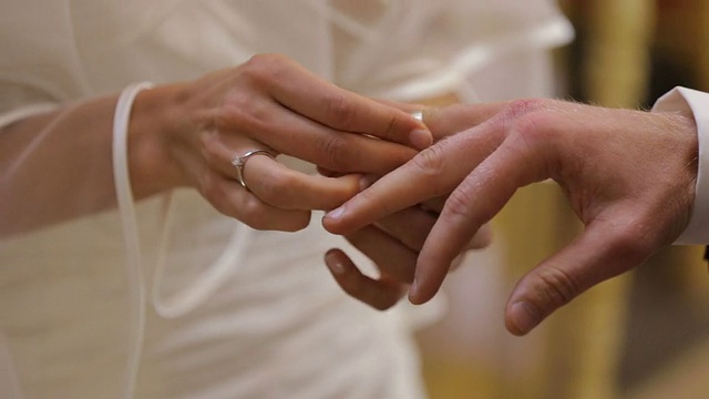 在宣誓仪式上把结婚戒指戴在新郎的手指上