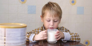 有趣的孩子高兴地喝奶粉