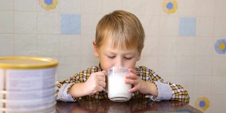 有趣的孩子高兴地喝奶粉