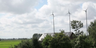 农舍上有三个小型风车和太阳能电池板