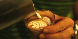 咖啡师倒牛奶制作拉花艺术。