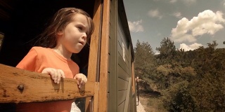 火车上的孩子——一个小女孩享受她的第一次火车旅行。山景窗外。