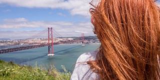 在葡萄牙里斯本，一个女人看着25日的大桥