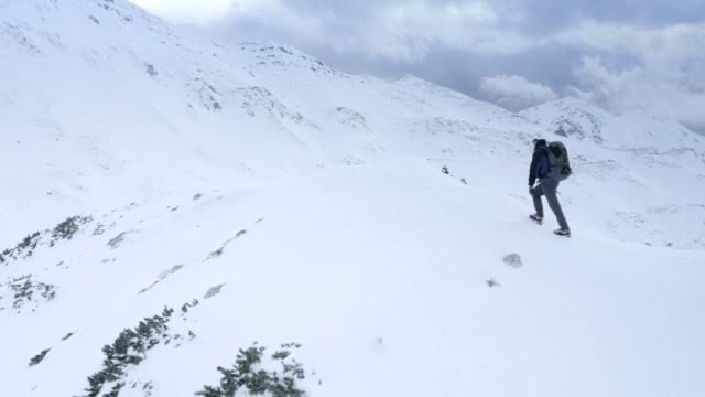 冬季登山运动员在到达山顶时举起双手