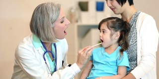 儿科医生检查一个小孩的喉咙