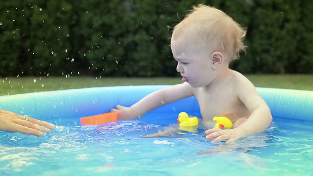 婴儿在小池子里溅水
