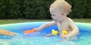 婴儿在小池子里溅水