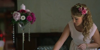 中镜头，一个年轻女子在为婚宴准备餐桌