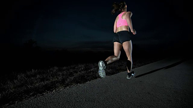 SLO MO PAN女性在晚上跑步