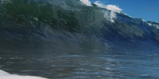 一个完美美丽的波POV波浪打破相机在加利福尼亚夏天的阳光浅沙滩上。慢动作在红龙上以300FPS的速度拍摄。