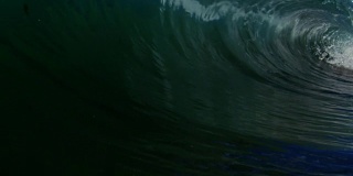 令人惊叹的桶波POV作为波浪打破了相机在加利福尼亚夏天的阳光浅沙滩上。慢动作在红龙上以300FPS的速度拍摄。