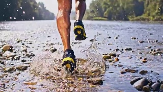 一个男人在一条浅河里奔跑视频素材模板下载
