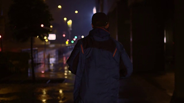 SLO MO TS男性跑步者晚上在城市里跑步