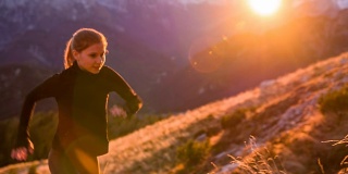 一个年轻女子在日落时分跑上了山