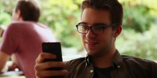 一个年轻人在网吧发短信。