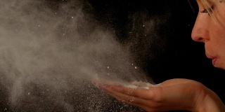 女人用手吹面粉