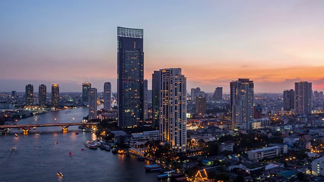 从白天到晚上，4k时间的现代建筑在河边，在泰国曼谷的桥上交通