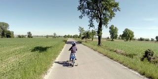 蹒跚学步的孩子正在学习骑他的新自行车