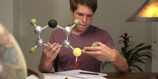 青少年通过研究分子模型来学习科学