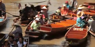 在Damnoen Saduak水上市场，木船忙着运送人