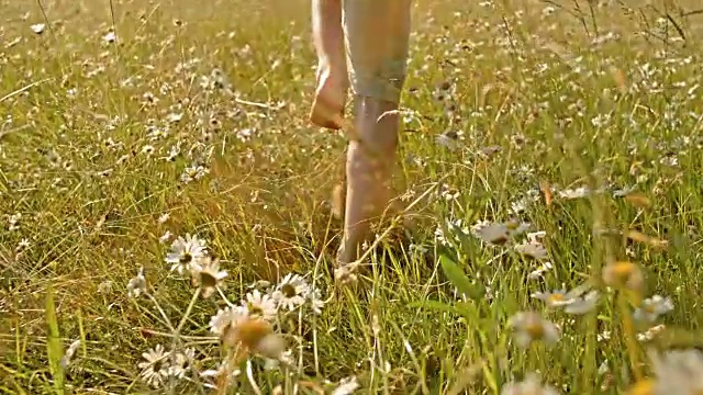 SLO MO TS赤脚男孩在高草地上奔跑