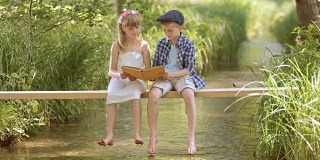 一个男孩和一个女孩坐在人行桥上看书