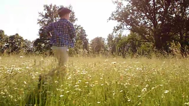 一个小男孩和一个女孩跑过夏天的草地
