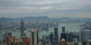 4k，俯瞰香港城市景观，俯瞰太平山顶，展现繁忙的维多利亚港和中国香港中环金融区，香港岛的天际线和一对鹰在城市上空飞翔。