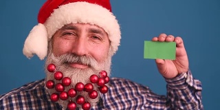 有胡子的老人戴着优雅的圣诞老人帽，背景是蓝色的