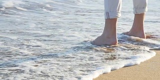 一个人的脚在沙子里的特写。