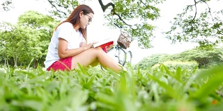 年轻女子坐在公园里看书