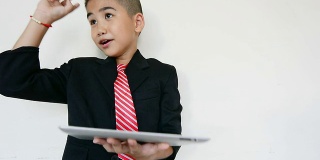 有趣的小男孩使用数字平板电脑和笔记本电脑