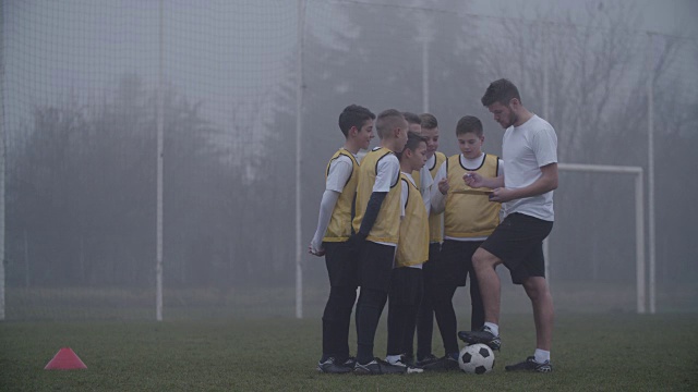 4K:教练指导他的孩子足球队。