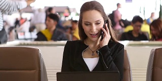 HD:在机场用手机工作的女商人。